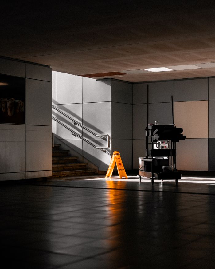 The Art of Drawing Readers In: Your attractive post title goes here A well-lit underground corridor featuring stairs, cleaning supplies, and warning signs.